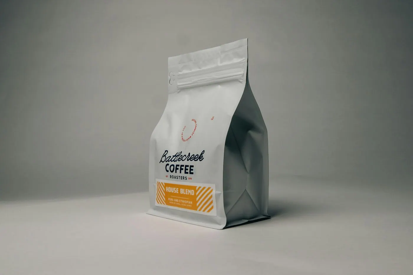 Pungă de boabe de cafea proaspăt prăjite, cu eticheta prăjitoriei la vedere